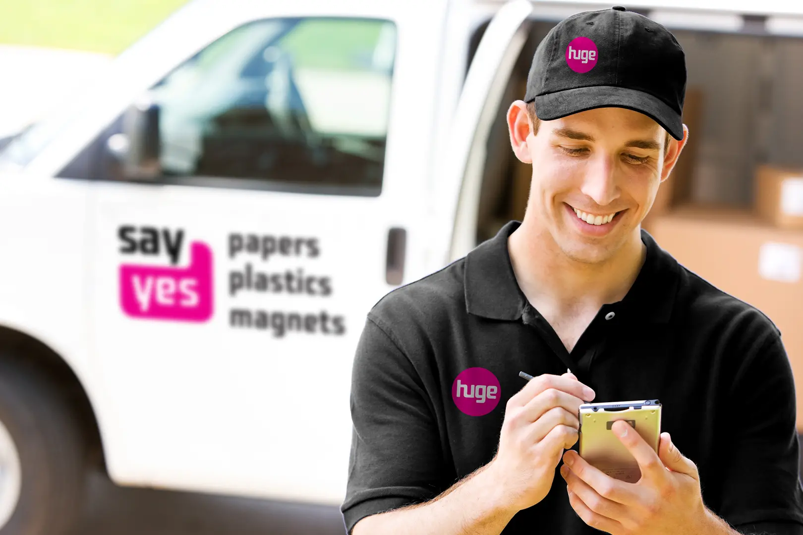 Huge Paper Delivery Man Stnding in front of an open van delivery of papers taking notes on a notepad